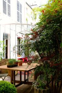a patio with a wooden table and some plants at Le 66 in Paris