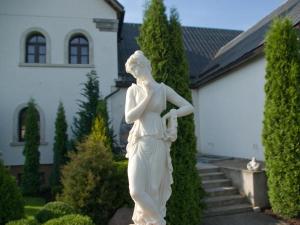 a statue of a woman in front of a house at Bellavilla in Vilnius