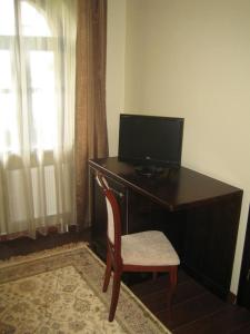 a desk with a television and a chair in a room at Bellavilla in Vilnius