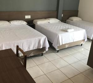 Łóżko lub łóżka w pokoju w obiekcie Hotel Comodoro