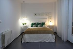 a bedroom with a large bed with green pillows at Los Tejares del Alcazar in Córdoba