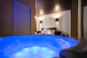 a large blue tub in a room with a bedroom at Villa Asfodelo Guest House & Relax in Alghero