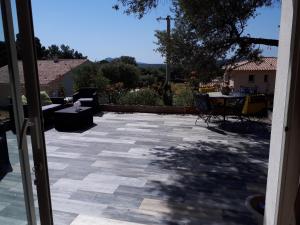 Une porte ouverte s'ouvre sur une terrasse avec une table. dans l'établissement gite tomasini sabrina zirilla, à Monacia-dʼAullène