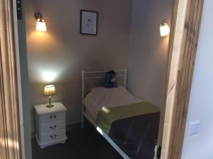 a small bedroom with a bed and a night stand at Tracey's Farmhouse Cottage in Belfast