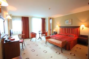 a bedroom with a bed and a table and chairs at Efir in Stara Zagora