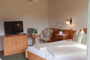 um quarto com uma cama e uma televisão de ecrã plano em Schmiedbauernhof em Fuschl am See