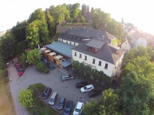 una vista in alto di un edificio con auto parcheggiate in un parcheggio di Burghotel Stolpen a Stolpen