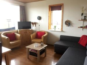 ein Wohnzimmer mit einem Sofa, 2 Stühlen und einem Tisch in der Unterkunft Europa-Feriendorf Husen in Husen