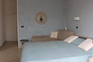 una camera con letto, divano e specchio di Les Agrumes a Varigotti