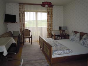 1 Schlafzimmer mit 2 Betten, einem Tisch und Stühlen in der Unterkunft Gästehaus Jedinger in Oberhofen am Irrsee