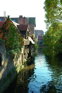 a river in a city with houses and buildings at Luxury Guesthouse Bonifacius - unique location in Bruges