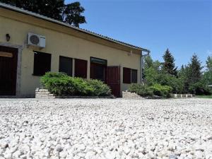 a building with a lot of rocks in front of it at Nyárfás Vendégház in Szeged