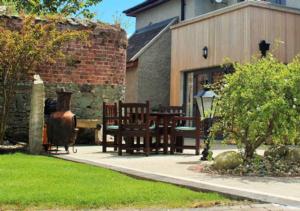 un patio con 2 bancos de madera y un edificio en Woodvilla Lodge en Kilmore