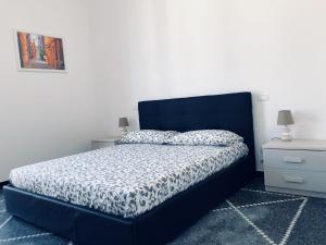 Schlafzimmer mit einem Bett mit blauem Kopfteil in der Unterkunft Appartamento "Dolce Nelly" in Sestri Levante