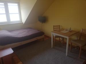 Dormitorio pequeño con cama y mesa en Pokoje u Bogusi en Międzyzdroje