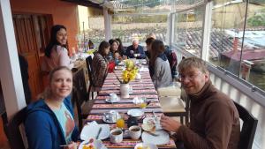 un gruppo di persone sedute a un lungo tavolo di Killari B&B a Ollantaytambo