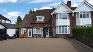 ein Backsteinhaus mit weißen Türen und einer Auffahrt in der Unterkunft Hampton Lodge En-Suite Rooms with Free Parking in Stratford-upon-Avon