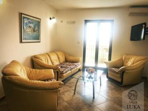 a living room with two couches and a coffee table at Apartments Villa Luka in Sveti Stefan