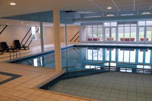 a large swimming pool in a building at Appartement Senang, Resort Amelander Kaap in Hollum