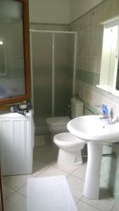 a bathroom with a toilet and a sink and a shower at Lovely House in Nebida