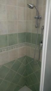 a bathroom with a shower with green tile at Lovely House in Nebida