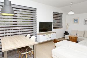 a living room with a table and a tv at Apartmán Chopok Juh Nadia in Horná Lehota