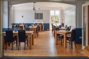 a dining room with wooden tables and chairs at The Randolph Hotel in Southwold