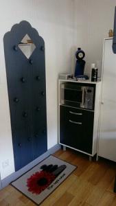 a bedroom with a blue door and a microwave at studio des écureuil in Gérardmer +5 photos