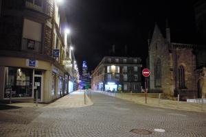 una calle de ciudad vacía por la noche con una señal de stop en Appartement Hyper centre - Quartier du château de Vire, en Vire