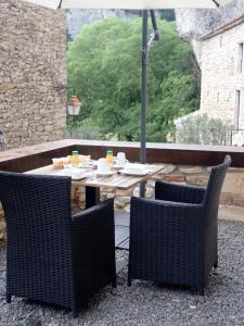 a patio with a table and chairs and an umbrella at Le Silex - Adult Only in Vallon-Pont-dʼArc