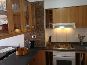 a kitchen with wooden cabinets and a stove top oven at Departamento Reñaca FRENTE AL MAR in Viña del Mar +10 photos