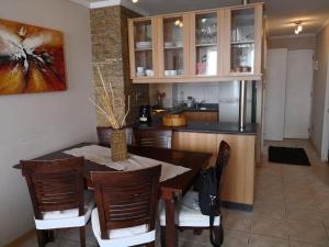 a kitchen and dining room with a table and chairs at Departamento Reñaca FRENTE AL MAR in Viña del Mar
