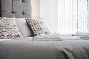 a bed with a pile of towels on top of it at Casa Fresa - King Street Apartments in Dundee