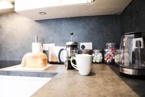 Casa Fresa - King Street Apartments في دندي: كاونتر توب مع آلة صنع القهوة والخبز