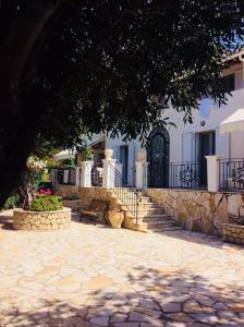 a house with a stone walkway in front of a building at Villa Ampelaki "30 meters to beach" in Paleokastritsa