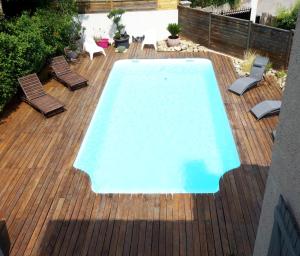 una piscina en una terraza de madera con sillas alrededor en Proche Centre Ville historique Aix avec PISCINE et grande terrasse Villa Pont de l'Arc, en Aix-en-Provence