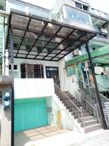 頭城的住宿－大溪漁港姸海地帶民宿，前方有蓝色门和楼梯的建筑