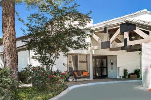 a white house with a patio and a tree at Value Suites Extended Stay - Arlington in Arlington