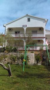 a house with a yard with a swing at Guesthouse BILI in Karlobag