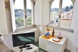 a living room with two large windows and a flat screen tv at Terrazza Bello in Portovenere