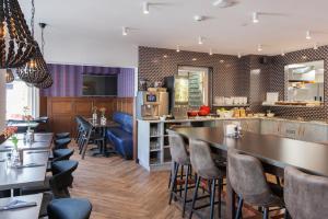 a restaurant with a bar and tables and chairs at Best Western Hotel Den Haag in The Hague