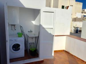 eine Waschküche mit Waschmaschine und Unterlegscheibe in der Unterkunft Casa casco antiguo, junto al Bufador in Peñíscola