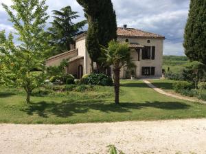 an old house with a palm tree in front of it at Chambre d'hotes la Quercynoise in Montaigu-de-Quercy