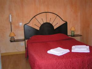 サラヴァにあるHotel Des Sitesのベッドルーム1室(赤いベッド1台、タオル2枚付)