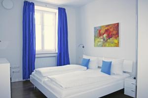 1 dormitorio con 1 cama con cortinas azules y ventana en Ferienwohnung Am Kurpark -Wohnung 2,90qm- en Garmisch-Partenkirchen