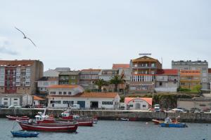 a group of boats in the water near a city at Hostal Residencia Bahía in Laxe