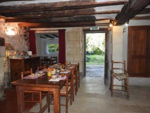 a dining room with a wooden table and chairs at Le Moulin De Saussaye in Crouzilles
