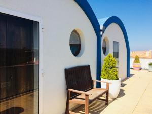 a chair sitting on a porch with two circular windows at Beach House Loft in Cortegaça
