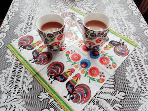 twee kopjes koffie bovenop een tafel bij Dom Na Ludowo w Brzeźnicy in Brzeźnica