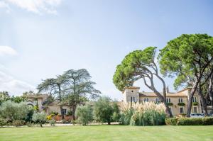 a large house with trees and a lawn at Le Mas de l'Espérance in Garons